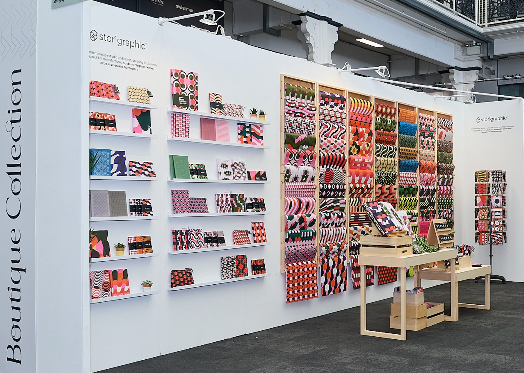 The Storigraphic stand at a trade show, with notebooks, wrapping paper and cards on display